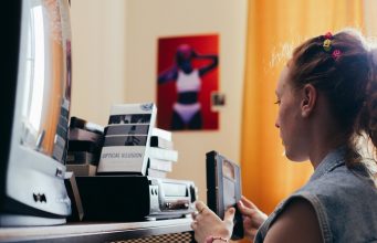 osoba podešava gramofonsku ploču